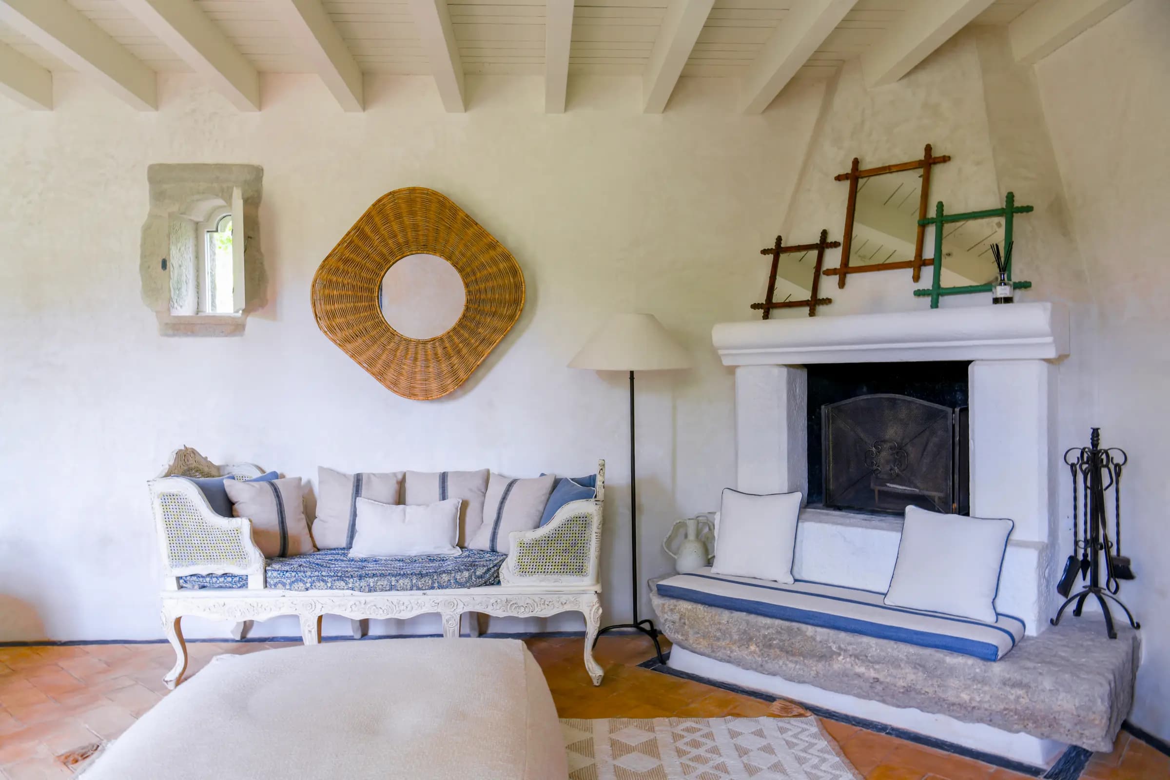 The cottage sitting room — a daybed beside the open fireplace