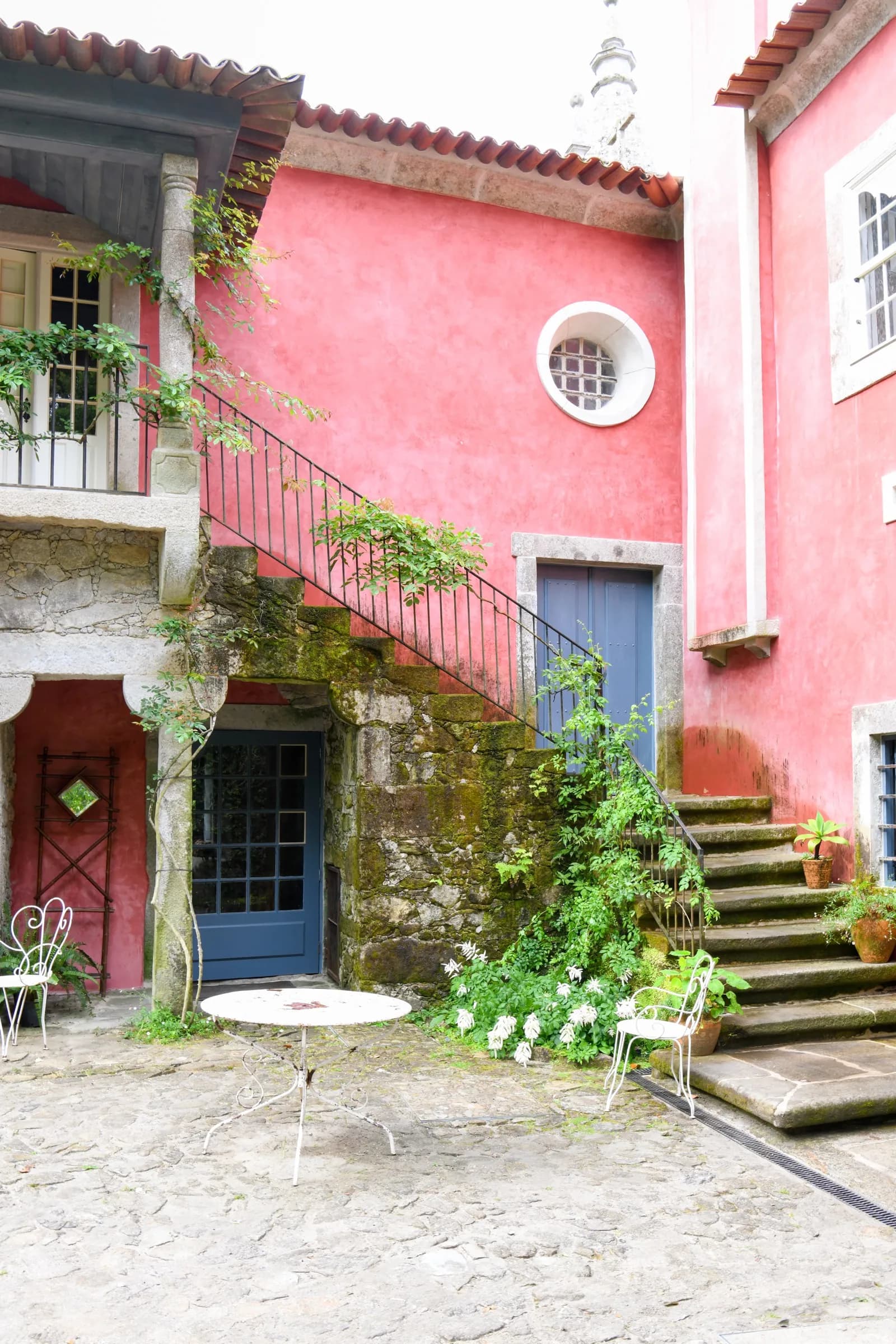 The rose-washed inner courtyard with its stone stair and potted plants