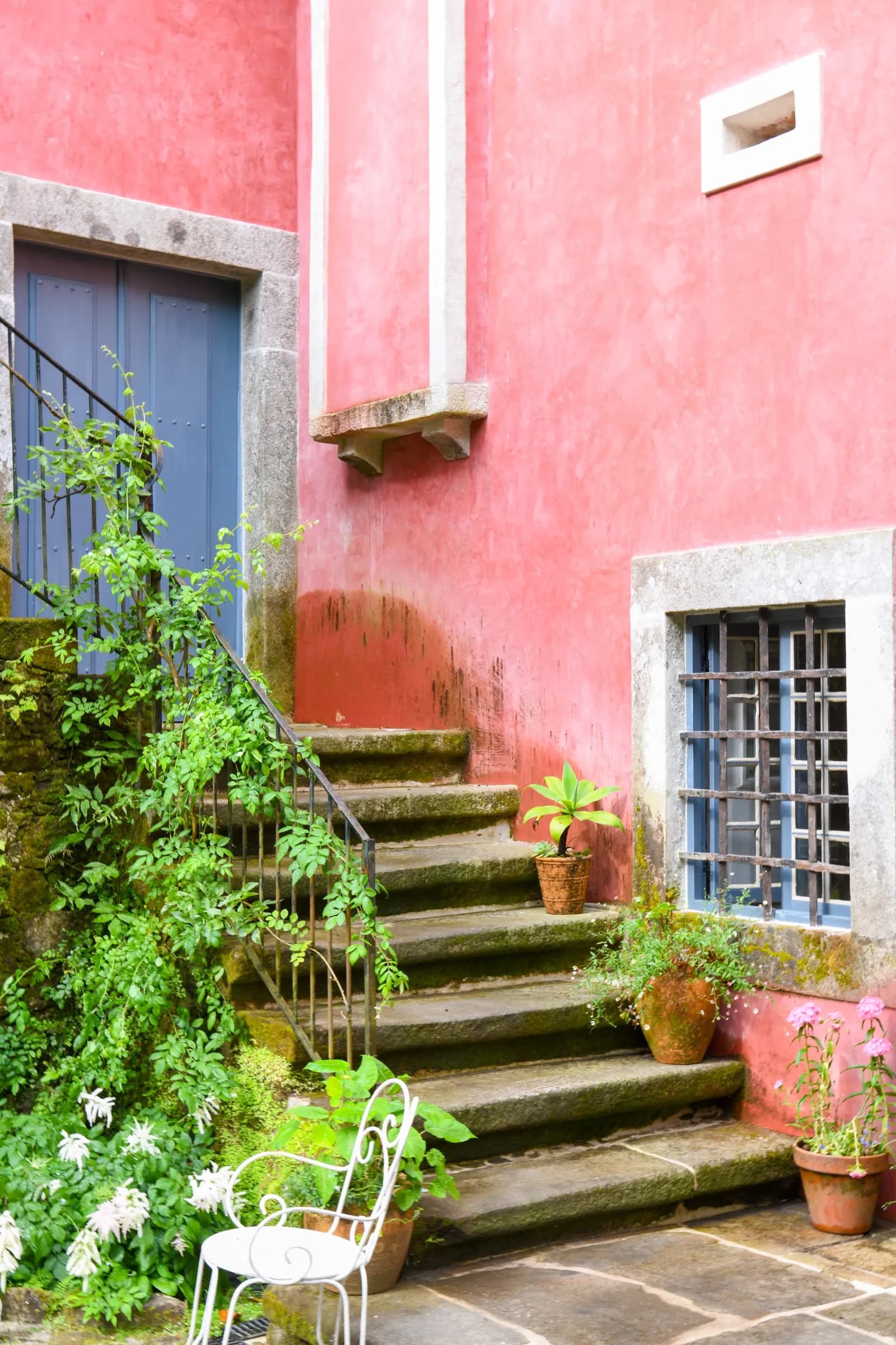 Weathered stone steps climbing the terracotta courtyard wall
