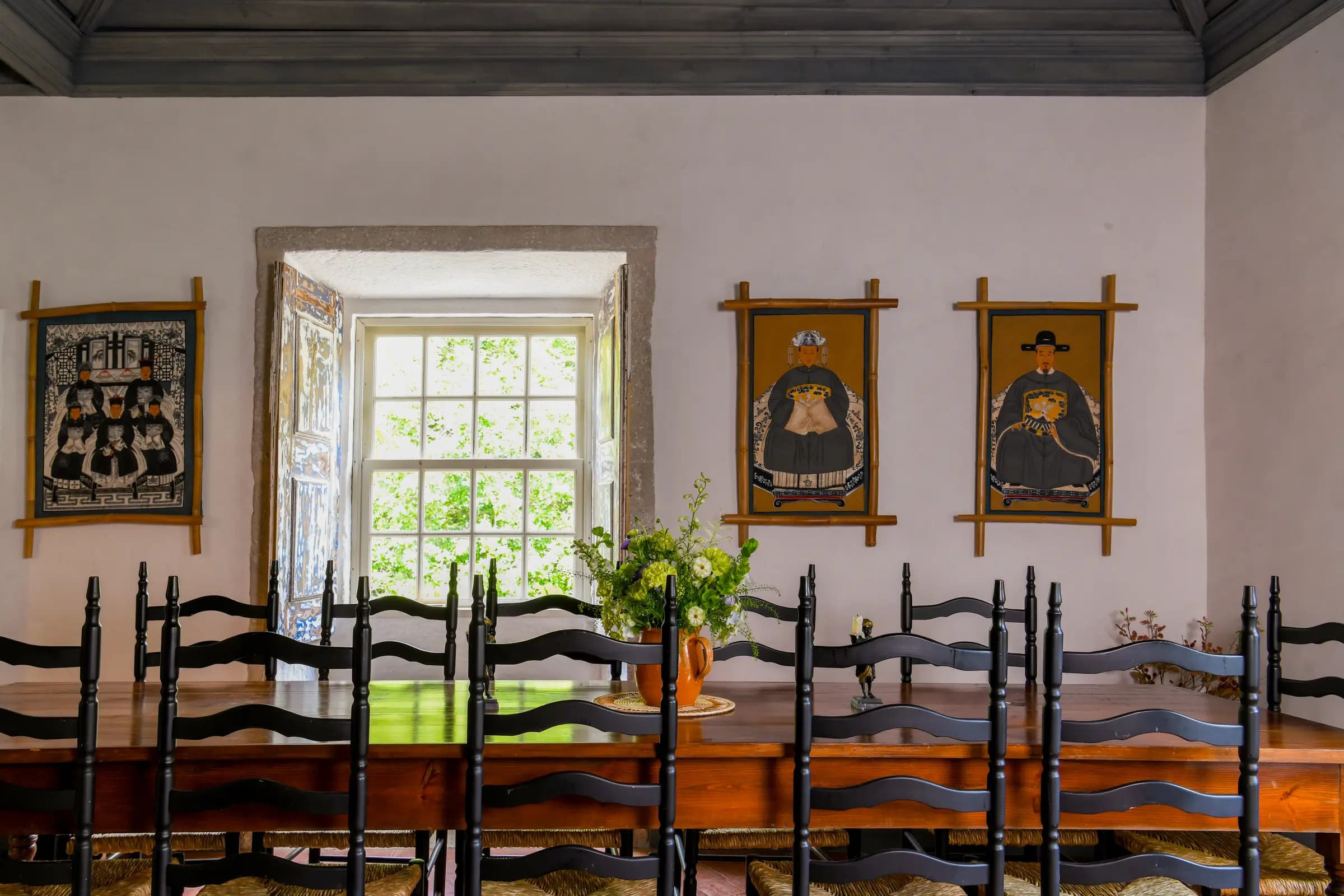 The long Blue Kitchen table beneath portraits of Benedictine monks