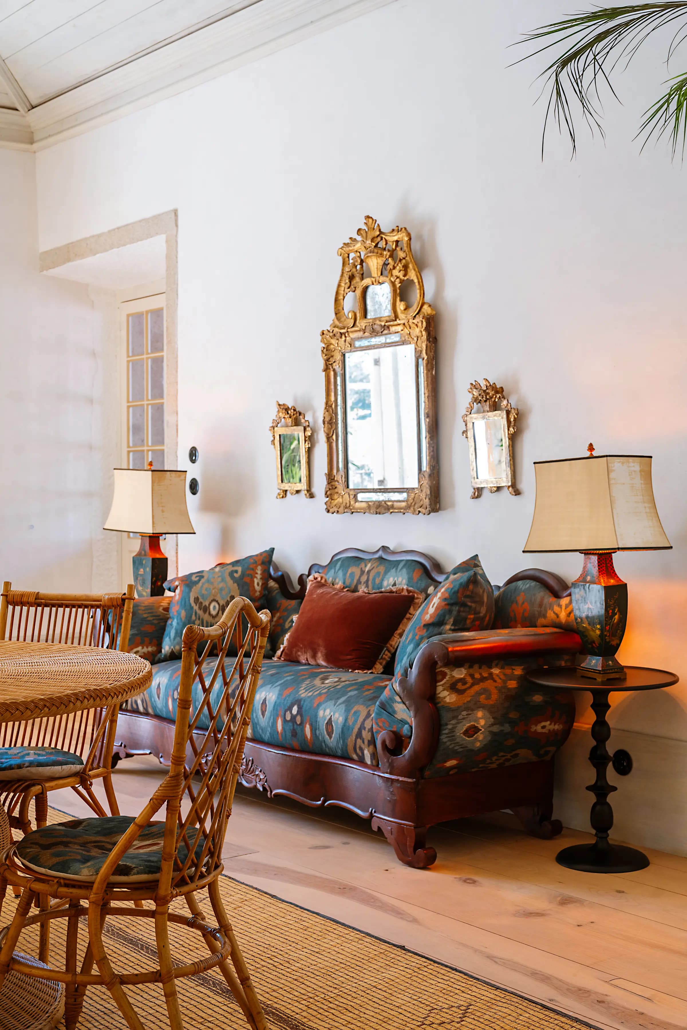 The salon — an antique sofa, gilt mirrors and warm lamplight