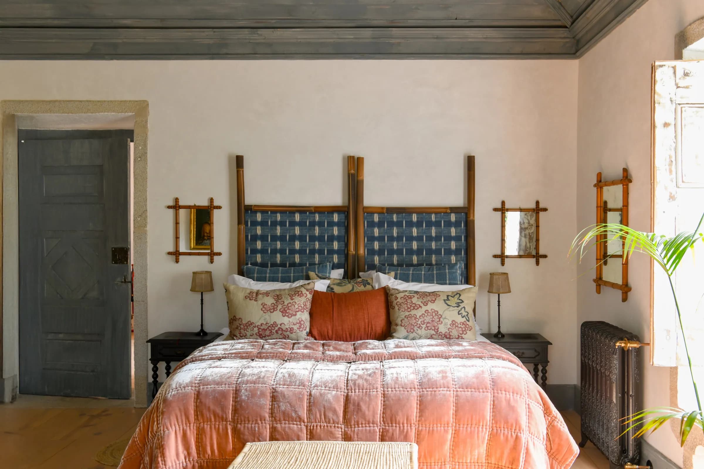 The Dahlia suite — a coral bedspread beneath azulejo headboards